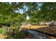 Community playground featuring swings, slides, and various play structures amid a natural, wooded setting at 1 Marlow Dr, Charleston, SC 29403