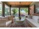 Inviting sunroom with comfortable wicker seating, brick wall accent, and a view of the surrounding neighborhood at 1 Marlow Dr, Charleston, SC 29403
