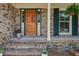 Inviting front porch with brickwork, a wood door and tasteful landscaping at 1006 Ibis Ct, Mount Pleasant, SC 29464