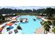 Aerial view of community's expansive pool with ample lounge seating, umbrellas, and lush landscaping at 1017 Swamp Rose Run, Summerville, SC 29485