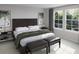 Stylish bedroom featuring a dark wood headboard, neutral walls, and natural light from large windows at 1017 Swamp Rose Run, Summerville, SC 29485