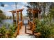 Inviting wooden dock with pergola overlooks a tranquil lake, offering a peaceful retreat at 1021 Swamp Rose Run, Summerville, SC 29485