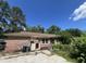 Back exterior of a brick house with an overgrown yard and detached garage; needs maintenance at 1022 Miles Jamison Rd, Summerville, SC 29485