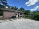 The backyard of a brick home features a concrete pad and doorway, showing signs of deferred maintenance at 1022 Miles Jamison Rd, Summerville, SC 29485