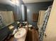 A bathroom with dark blue walls, single sink vanity, and a shower-tub combo at 1022 Miles Jamison Rd, Summerville, SC 29485