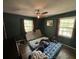 Bedroom with dark green walls, two windows, and ceiling fan; needs repairs at 1022 Miles Jamison Rd, Summerville, SC 29485