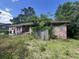 View of home showing overgrown vegetation, brick facade, entry door, and deferred maintenance at 1022 Miles Jamison Rd, Summerville, SC 29485