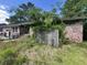 View of home showing overgrown vegetation, brick facade, entry door, and deferred maintenance at 1022 Miles Jamison Rd, Summerville, SC 29485
