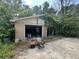 Detached garage with two open doors, overgrown vegetation, and a deteriorating driveway at 1022 Miles Jamison Rd, Summerville, SC 29485