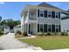 Charming two-story home with a inviting front porch, lush green lawn and manicured landscaping at 104 Pine Waters Ln, Summerville, SC 29483