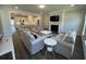 Bright and airy living room with fireplace, modern furniture, and open-concept layout leading to the kitchen at 104 Pine Waters Ln, Summerville, SC 29483