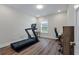 Bright bonus room features a treadmill, desk, wood floors, and natural light from the window at 104 Pine Waters Ln, Summerville, SC 29483