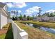 Scenic community with a pond, lush greenery, and charming homes under a blue sky with fluffy clouds at 104 Pine Waters Ln, Summerville, SC 29483