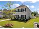 Beautiful two-story home with black shutters, and lush green landscaping, enhancing curb appeal at 104 Pine Waters Ln, Summerville, SC 29483