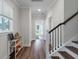 Bright hallway with wood floors, white trim, staircase and natural light that leads to the home's entrance at 104 Pine Waters Ln, Summerville, SC 29483