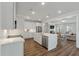 Open-concept kitchen with stainless steel appliances, white cabinets, quartz countertops, and a breakfast bar with an island at 104 Pine Waters Ln, Summerville, SC 29483