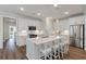 Modern kitchen features white cabinets, stainless steel appliances, a large island with seating, and hardwood floors at 104 Pine Waters Ln, Summerville, SC 29483