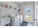 Bright laundry room with washer, dryer, sink, storage, and stylish tiled floor at 104 Pine Waters Ln, Summerville, SC 29483