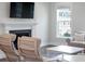 Inviting living room featuring a cozy fireplace, modern decor, and abundant natural light from a large window at 104 Pine Waters Ln, Summerville, SC 29483