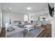 Bright living room with modern furnishings, hardwood floors, and open-concept design to the kitchen area at 104 Pine Waters Ln, Summerville, SC 29483