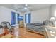 Brightly lit bedroom with ceiling fan, wood flooring, and a window with blue curtains at 105 Irish Oak Dr, Goose Creek, SC 29445