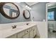 Well-lit bathroom featuring a double vanity and decorative round mirrors at 106 Wrigley Blvd, Summerville, SC 29485
