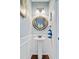 Powder room featuring white wainscoting, pedestal sink, and round mirror at 106 Wrigley Blvd, Summerville, SC 29485
