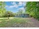 Backyard view with mature trees, providing shade and privacy, and showing the home's exterior at 108 Helen Dr, Summerville, SC 29483
