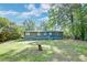 Rear view of a single-story home with a spacious green backyard and established trees at 108 Helen Dr, Summerville, SC 29483