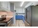 Galley kitchen featuring blue lower cabinets, white upper cabinets, stainless steel appliances and luxury vinyl floors at 108 Helen Dr, Summerville, SC 29483