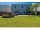 Large grassy backyard with a fire pit, outdoor seating, and a private patio area at 1110 Sapling Dr, Summerville, SC 29485