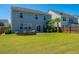 Spacious backyard with a fire pit, grill, patio, lush grass, and mature palm tree at 1110 Sapling Dr, Summerville, SC 29485