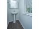 Small pedestal sink bathroom with wood-look floors and natural light from the window at 1110 Sapling Dr, Summerville, SC 29485
