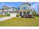 Attractive home featuring a two-car garage, manicured lawn, and welcoming front porch at 1110 Sapling Dr, Summerville, SC 29485