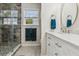 This bathroom features a glass shower with a gray tile surround, a white vanity, and a window at 112 Red Cypress Dr, Goose Creek, SC 29445