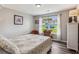 This bedroom features a patterned bedspread, a dresser in front of the window, and wood floors at 112 Red Cypress Dr, Goose Creek, SC 29445