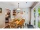 Bright dining area with hardwood floors, a wooden table, and an open layout connecting to the kitchen at 112 Red Cypress Dr, Goose Creek, SC 29445