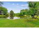 Idyllic pond surrounded by vibrant green lawns and mature trees, enhancing its natural beauty at 112 Red Cypress Dr, Goose Creek, SC 29445