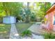 Lush backyard features a shed, deck, a concrete path, mature trees, and outdoor seating, perfect for relaxation at 1159 Camden St, North Charleston, SC 29405