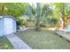 A fenced backyard with a storage shed, tropical tree, and a patio with outdoor seating at 1159 Camden St, North Charleston, SC 29405