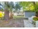 A backyard featuring a storage shed, tropical trees, and a patio set for relaxing and enjoying the outdoors at 1159 Camden St, North Charleston, SC 29405