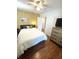 Bedroom featuring hardwood floors, ceiling fan, closet access, and geometric patterned wall at 1159 Camden St, North Charleston, SC 29405