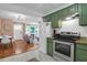 Charming kitchen featuring green cabinets, stainless steel appliances, and an open layout to the dining and living areas at 1159 Camden St, North Charleston, SC 29405