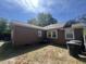 View of the back of the house with brown siding, white windows, and a small patio area at 117 Weiters St, Walterboro, SC 29488