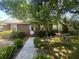 Beautiful single-story home featuring brown siding, lush landscaping, and a bird bath at 117 Weiters St, Walterboro, SC 29488