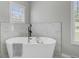 A modern soaker tub is located under a large window allowing for a view of the exterior at 123 Fall Creek Blvd, Summerville, SC 29483