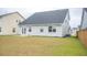 Large backyard featuring a light gray home, green grass, and privacy fence at 124 Long Trail Way, Moncks Corner, SC 29461