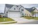 Charming two-story home featuring a well-manicured lawn and attached two-car garage, exuding curb appeal at 124 Long Trail Way, Moncks Corner, SC 29461
