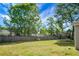 Lush backyard with green lawn, a wooden fence and mature trees, offering a private outdoor space at 129 Mockernut Dr, Ladson, SC 29456
