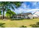 Spacious backyard with a trampoline, bordered by a wooden fence and lush greenery, offering ample play space at 129 Mockernut Dr, Ladson, SC 29456